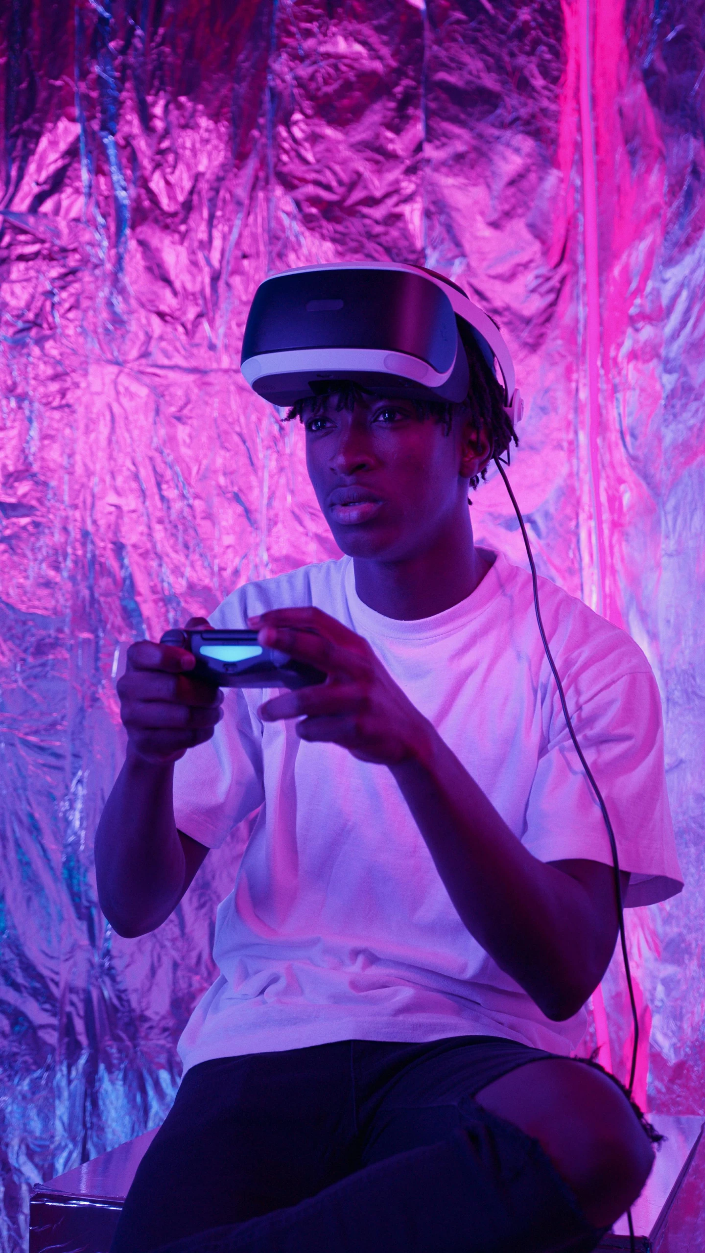 a man wearing a virtual reality headset playing a video game, by Carey Morris, pexels, afrofuturism, soft neon purple lighting, playboi carti portrait, instagram picture, black teenage boy