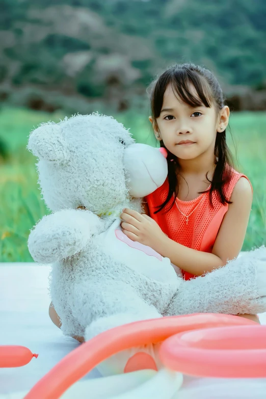 a little girl sitting on a blanket with a teddy bear, a picture, by irakli nadar, pexels contest winner, young asian girl, coronavirus as a stuffed toy, silver, a handsome