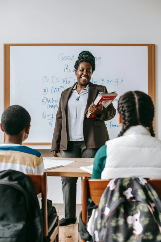 a woman standing in front of a class of children, pexels contest winner, american barbizon school, african american woman, learning, product introduction photo, casually dressed