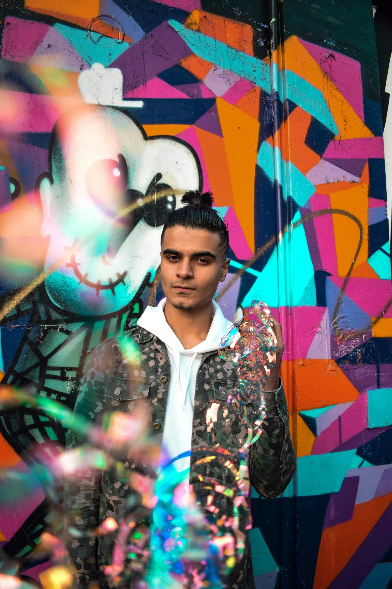 a man standing in front of a colorful wall, graffiti, asher duran, promotional picture, lights, profile image