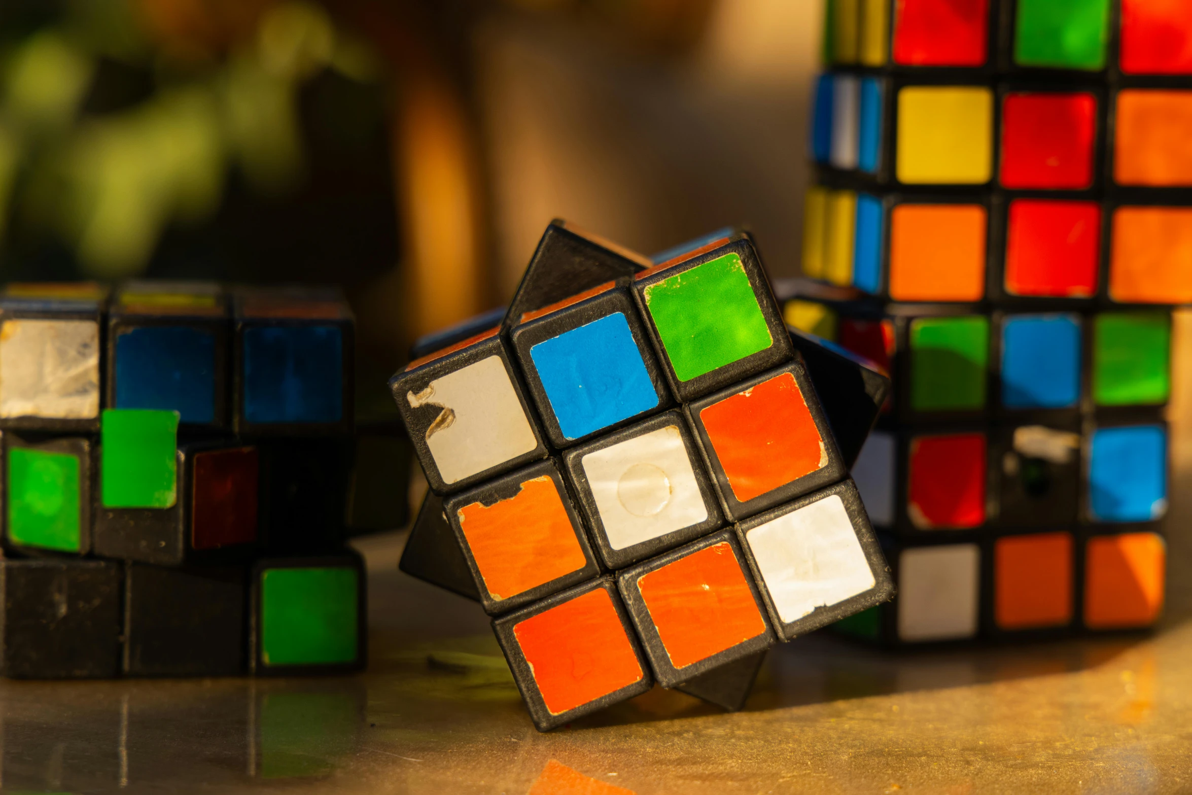 a couple of rubik cubes sitting on top of a table, in the evening