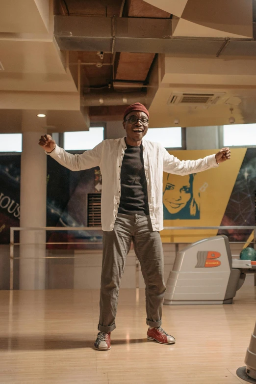 a man standing on top of a hard wood floor, an album cover, trending on unsplash, happening, brown skin man with a giant grin, bowling, movie still 8 k, in a mall