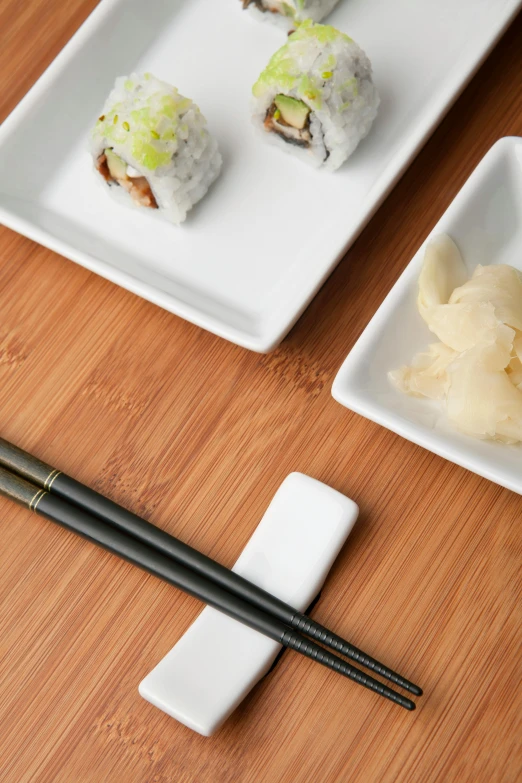 a wooden table topped with plates of food and chopsticks, eating sushi, soft white rubber, 2019 trending photo, square