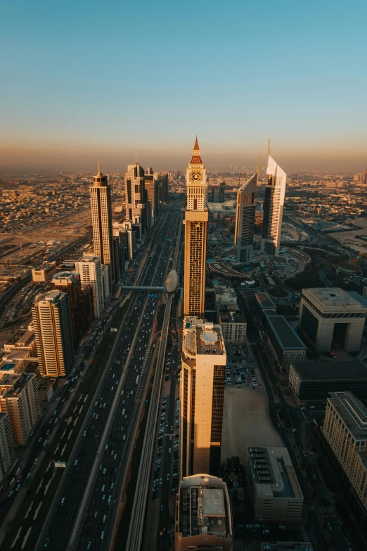 an aerial view of a city with tall buildings, by Erik Pevernagie, hurufiyya, desert with city in the skyline, during golden hour, cinematic shot ar 9:16 -n 6 -g, large tall