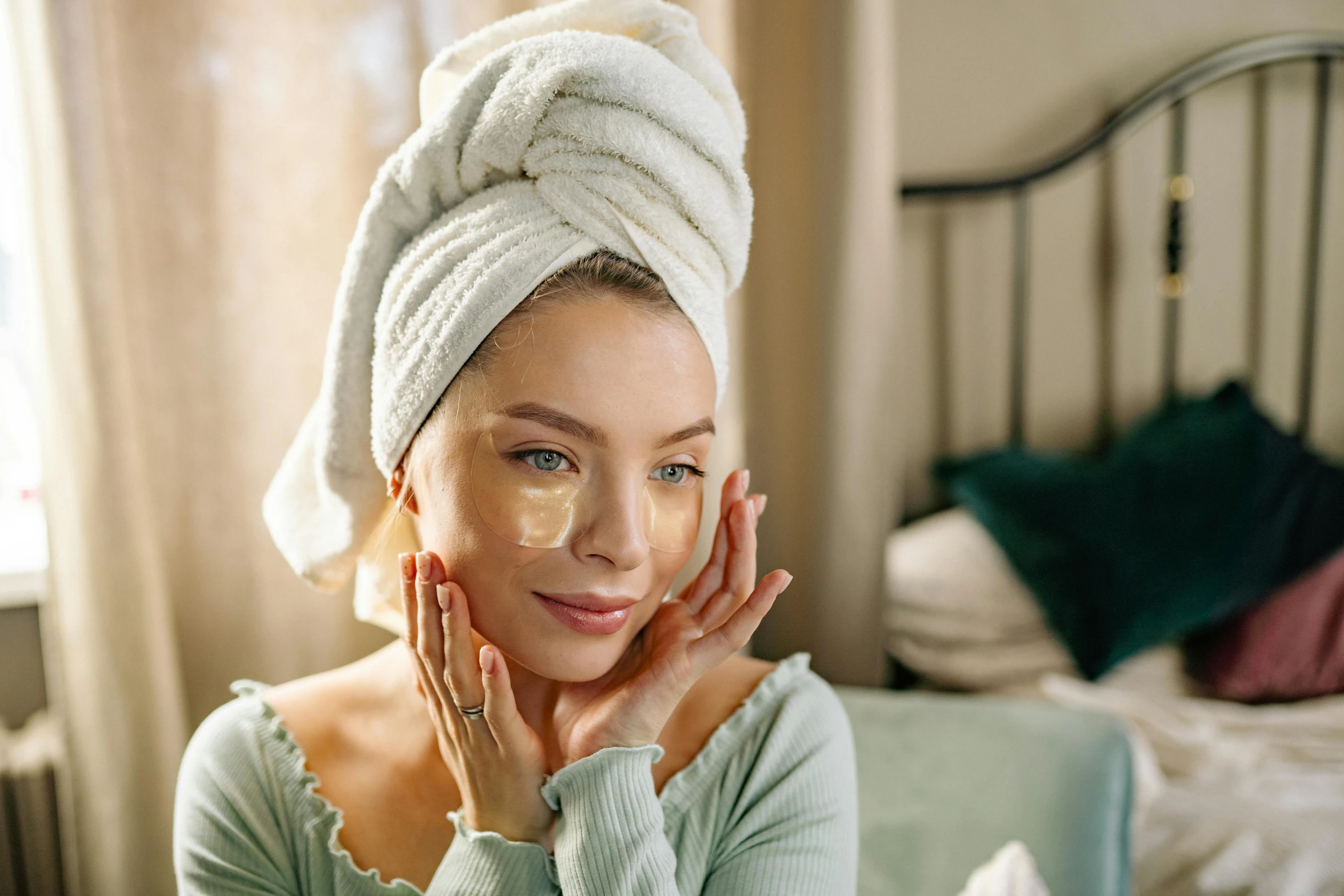 a woman sitting on a bed with a towel on her head, a portrait, trending on pexels, renaissance, beauty mark on cheek, manuka, bags under eyes, early evening