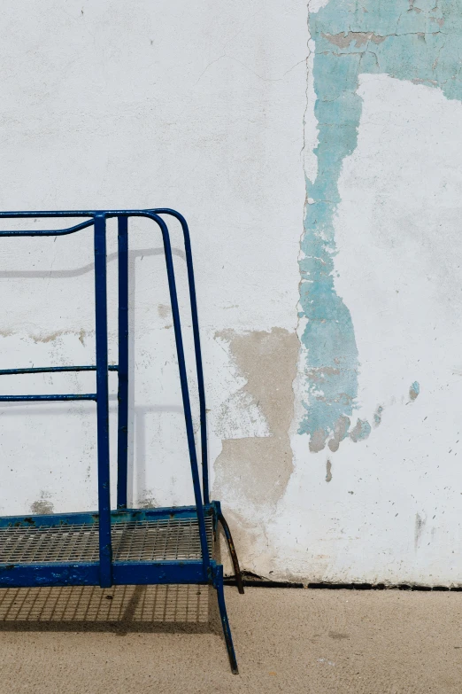 a blue ladder leaning against a white wall, by Elsa Bleda, trending on unsplash, a photograph of a rusty, cart, low quality photo, splash image