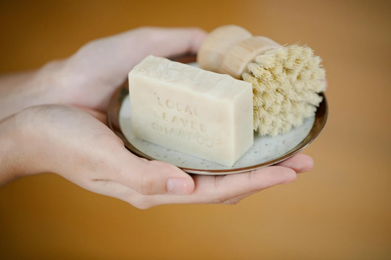 a person holding a bowl of soap and a brush, by Helen Stevenson, unsplash, etched inscriptions, official product photo, mini model, hand made