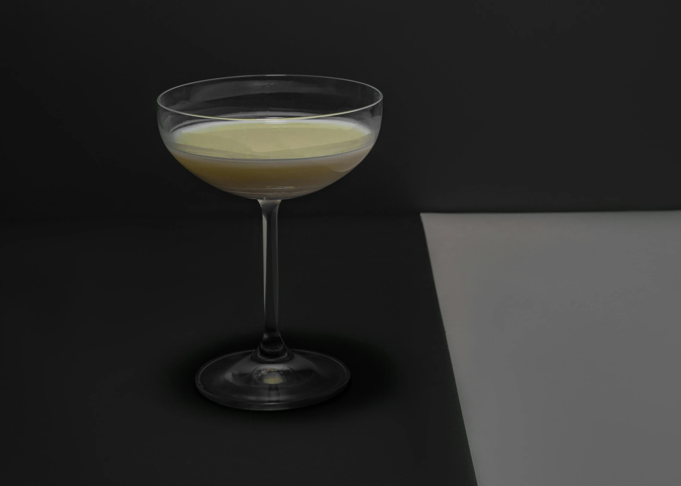 a glass filled with liquid sitting on top of a table, inspired by Ndoc Martini, purism, phosphorescent, beige mist, 2030s, raf grassetti