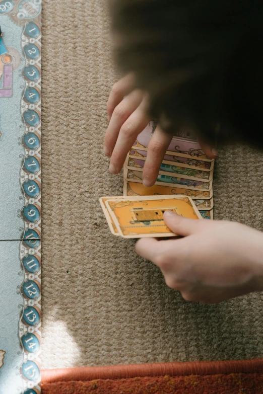 a person playing a card game on the floor, by Jessie Algie, pexels contest winner, cartographic, gamedev, promo image, construction