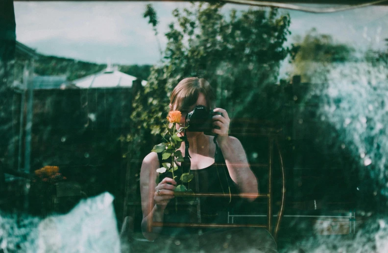 a woman taking a picture of herself in a mirror, a polaroid photo, inspired by Elsa Bleda, pexels contest winner, romanticism, flowers around, person made out of glass, medium format, outside