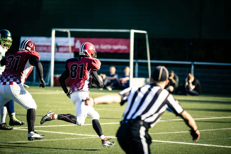 a group of young men playing a game of football, a tilt shift photo, by Sebastian Spreng, pexels contest winner, mid action swing, maroon, football armor, dark taint :: athletic