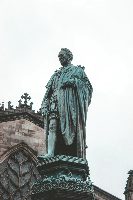 a statue of a man standing in front of a building, a statue, inspired by Master of Saint Giles, pexels contest winner, renaissance, made of bronze, portrait of a victorian duke, chesterfield, wearing a royal robe