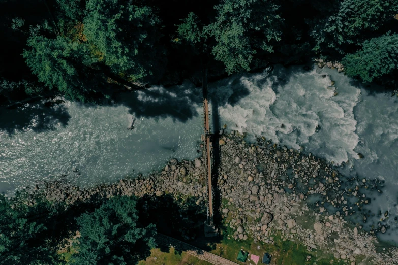a river running through a lush green forest, an album cover, pexels contest winner, hurufiyya, high angle view, wooden bridge, whistler, helicopter view