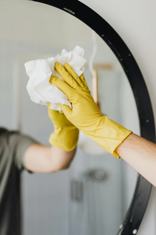 a person in yellow gloves cleaning a mirror, pexels, square, porcelain organic tissue, asian man, on high-quality paper