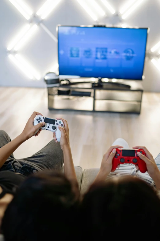 two people sitting on a couch playing a video game, pexels, tv screens, connectivity, educational, high angle shot