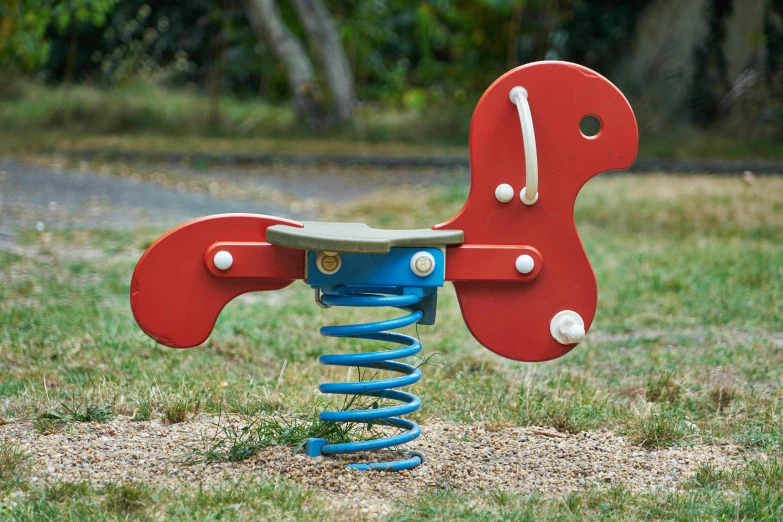 a red rocking horse sitting on top of a blue spring, inspired by Alexander Stirling Calder, dribble, activity play centre, sitting on a park bench, flying screw, 'groovy'