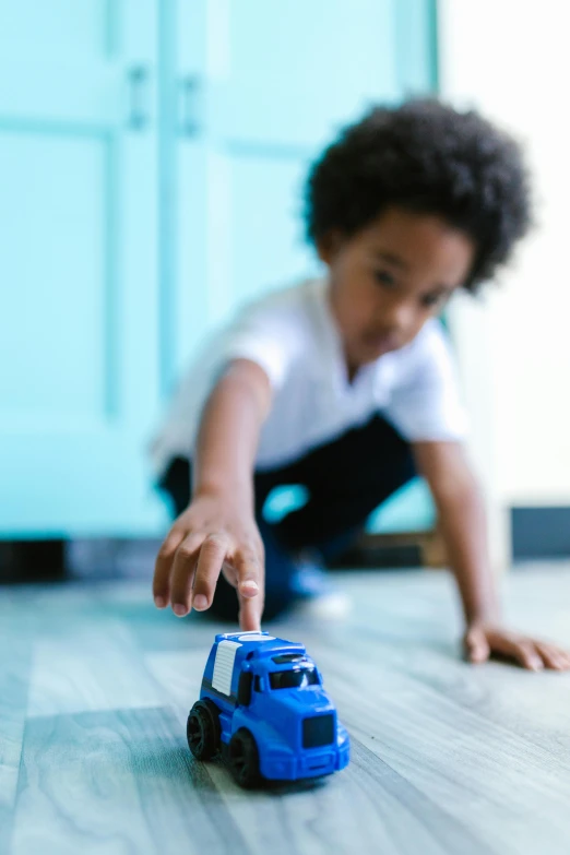 a child playing with a toy truck on the floor, by Dan Content, promo image, miniature of a sports car, getty images, blue print