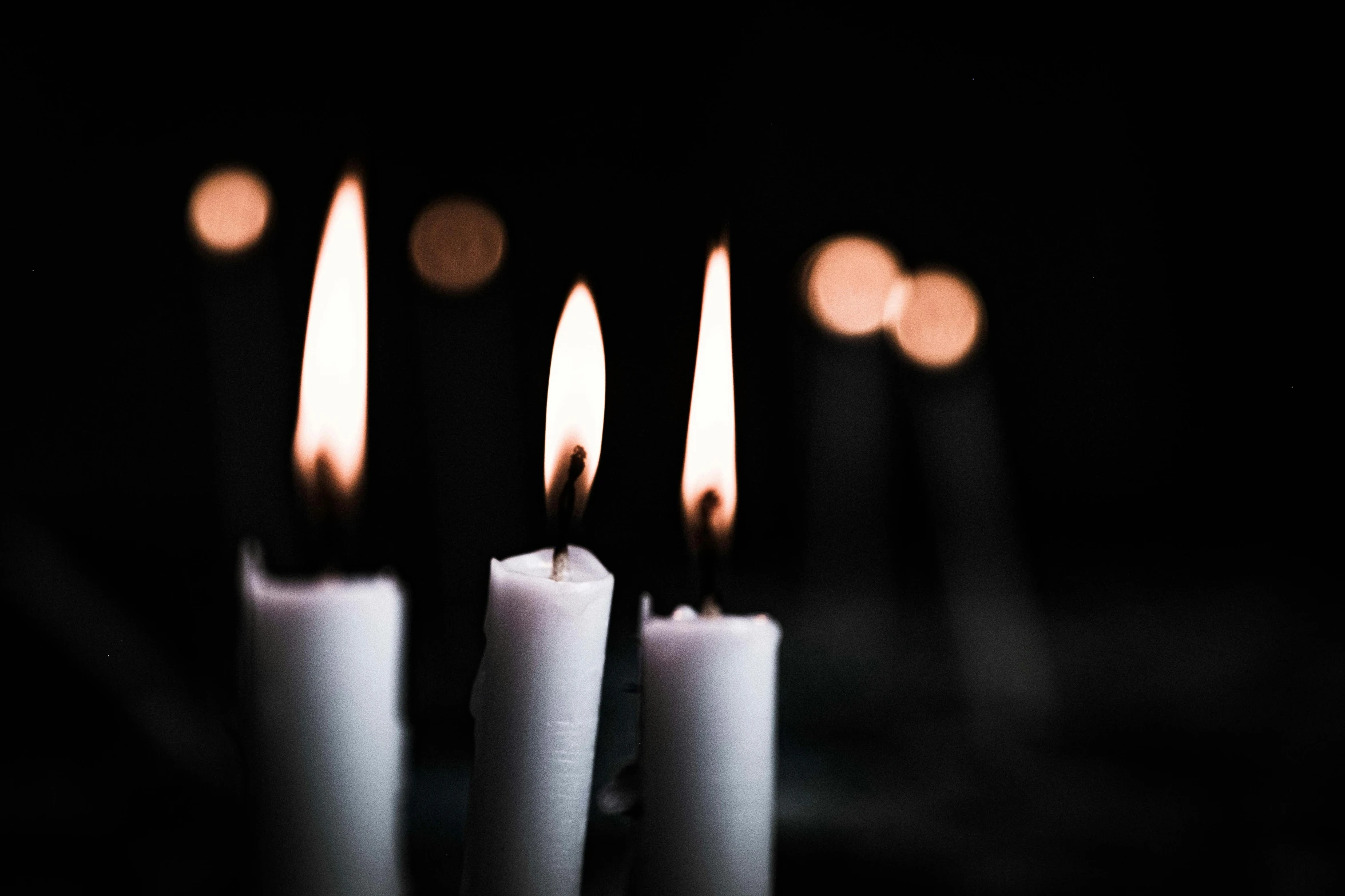 a group of white candles sitting next to each other, a black and white photo, inspired by Elsa Bleda, unsplash, ignant, extremely scary, profile image, brightly-lit