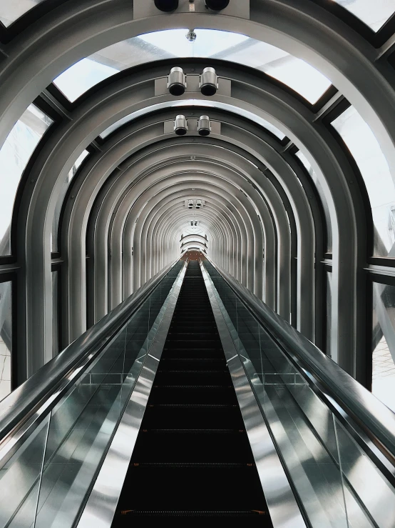 an escalator going down the middle of a tunnel, inspired by Thomas Struth, unsplash contest winner, hypermodernism, space elevator, trending on vsco, album cover, eyelevel perspective image
