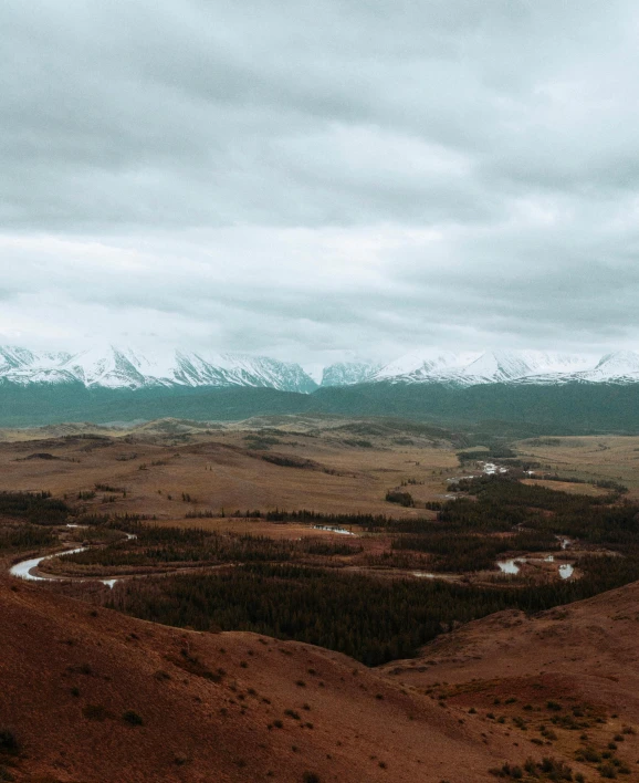 a view of the mountains from the top of a hill, by Emma Andijewska, unsplash contest winner, hurufiyya, wind river valley, slight overcast weather, ariel view, low quality photo