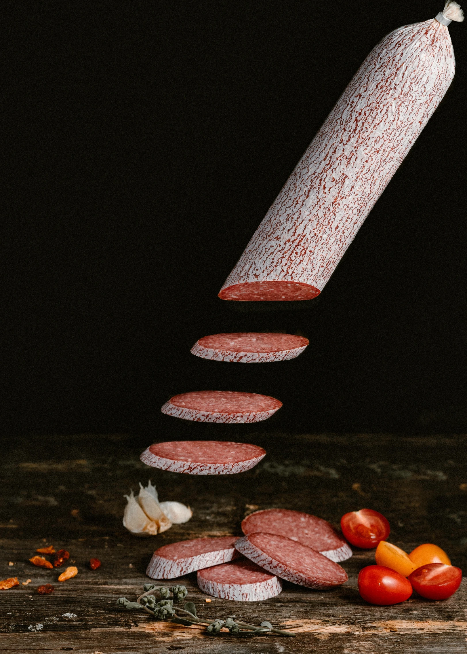 a sausage being sliced into slices on top of a wooden table, a portrait, pexels contest winner, art nouveau, product display photograph, red velvet, on a gray background, meat and lichens