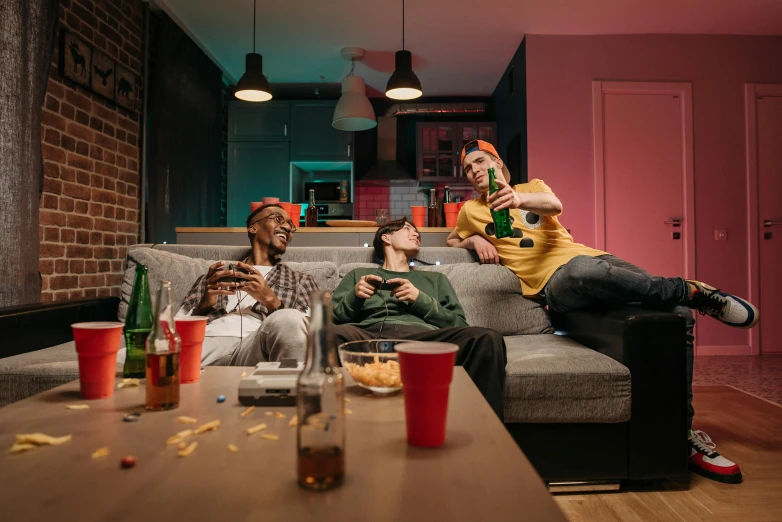 a couple of men sitting on top of a couch, pexels, gaming room, photograph of three ravers, fancy dress, in house