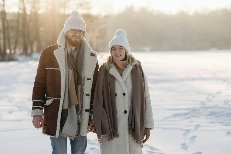 a man and a woman walking in the snow, a portrait, by Eero Järnefelt, pexels, wearing beanie, brown tuffle coat, white, romantic lead