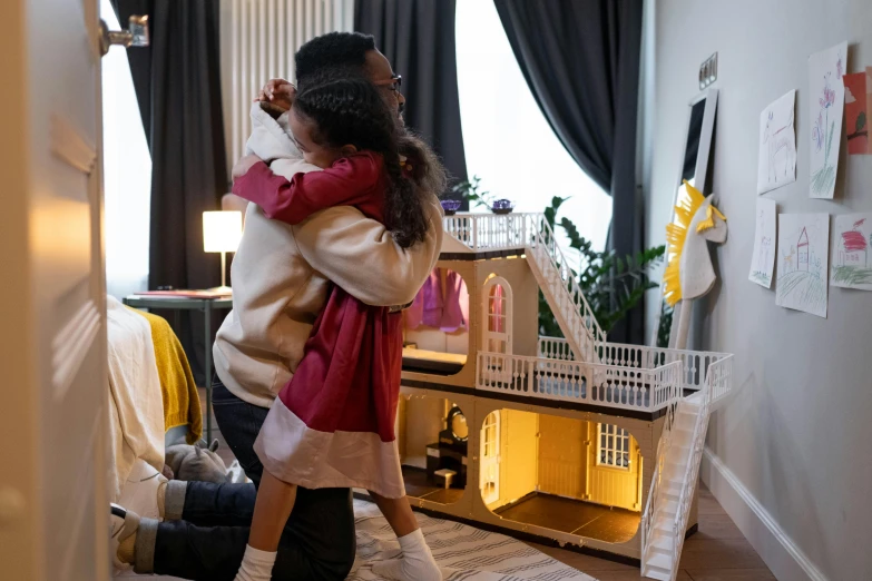 a little girl standing in front of a doll house, by Julia Pishtar, pexels contest winner, hugging each other, father with child, ( ( dark skin ) ), decoration