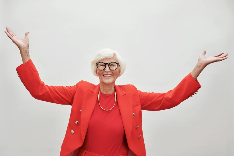 a woman wearing glasses and a red jacket, by Gavin Hamilton, pexels contest winner, triumphant pose, white-haired, 15081959 21121991 01012000 4k, plain background