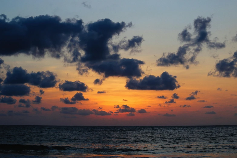 a sunset over the ocean with clouds in the sky, a picture, vacation photo, image