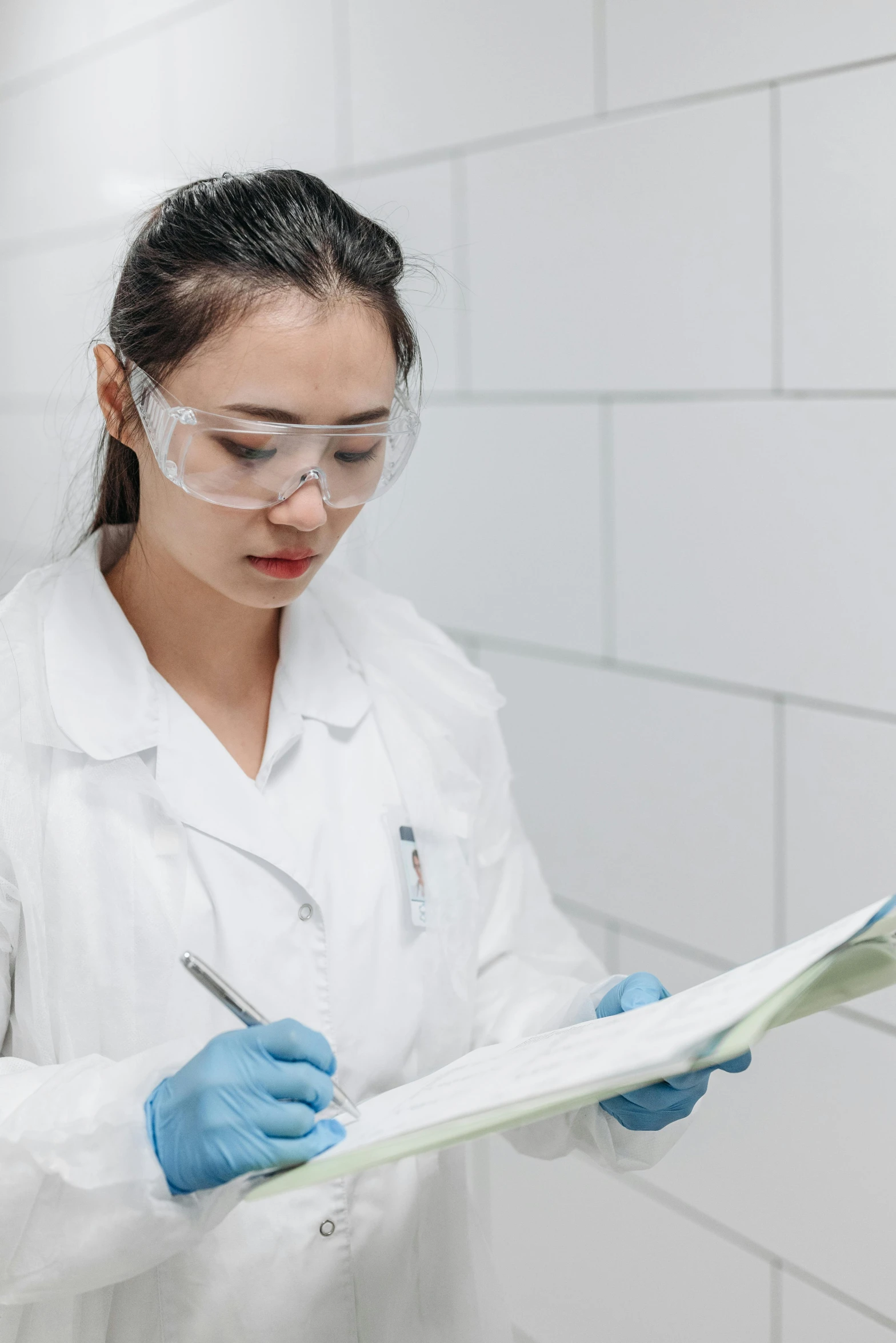 a woman in a lab coat and goggles writing on a piece of paper, asian human, multiple stories, maintenance, profile image