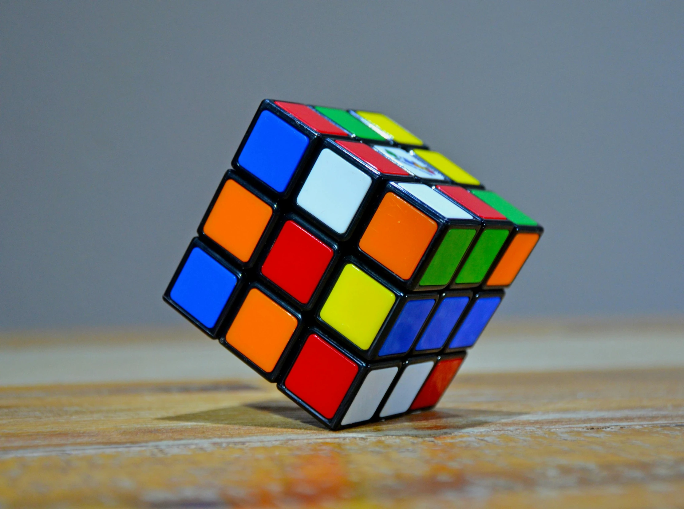 a rubik cube sitting on top of a wooden table, inspired by Ernő Rubik, pexels, square, gif, multicolored, technical