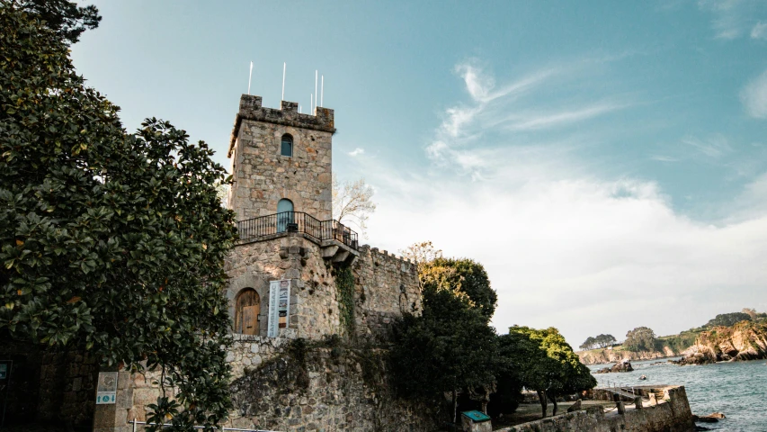 a stone building sitting next to a body of water, renaissance, castle on the mountain, são paulo, exterior photo, tower