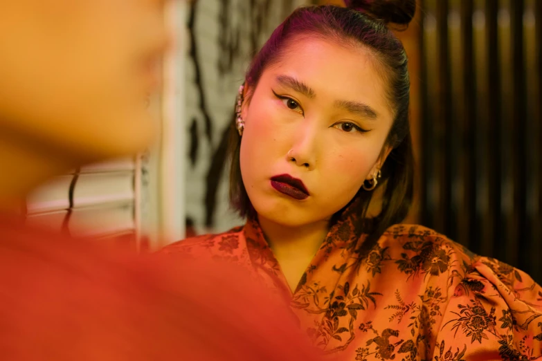 a woman looking at her reflection in a mirror, an album cover, inspired by Xie Huan, trending on pexels, ukiyo-e, evening makeup, fashionweek backstage, non binary model, ethnicity : japanese