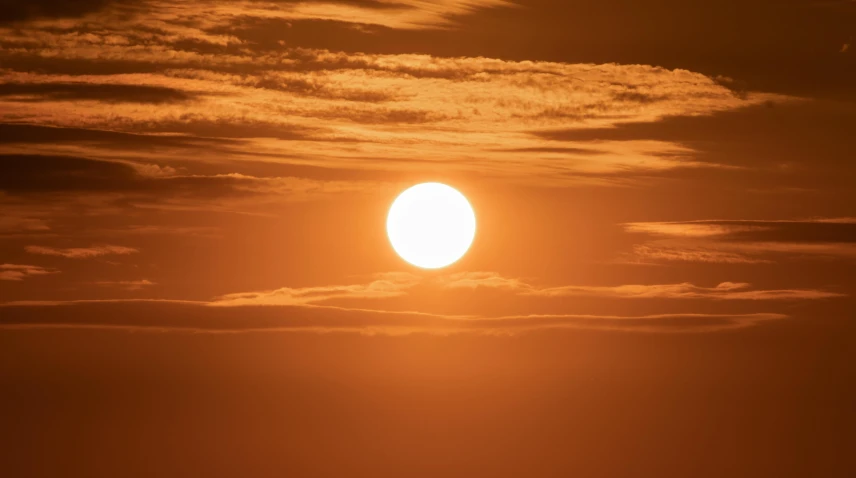 the sun is setting over a body of water, by Matthew Smith, pexels, large sun in sky, heat shimmering, solar, sun shaft