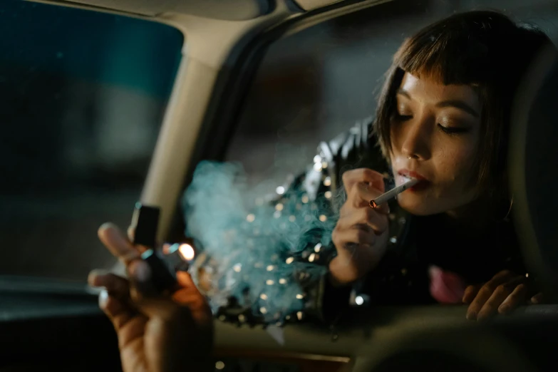 a woman sitting in a car smoking a cigarette, inspired by Elsa Bleda, trending on pexels, gendo ikari smoking a joint, kiko mizuhara, flares anamorphic, taking mind altering drugs