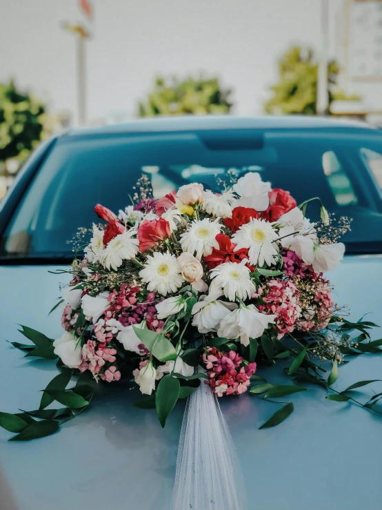 a bouquet on the hood of a car, trending on unsplash, multiple stories, celebrating an illegal marriage, centerpiece, attractive photo