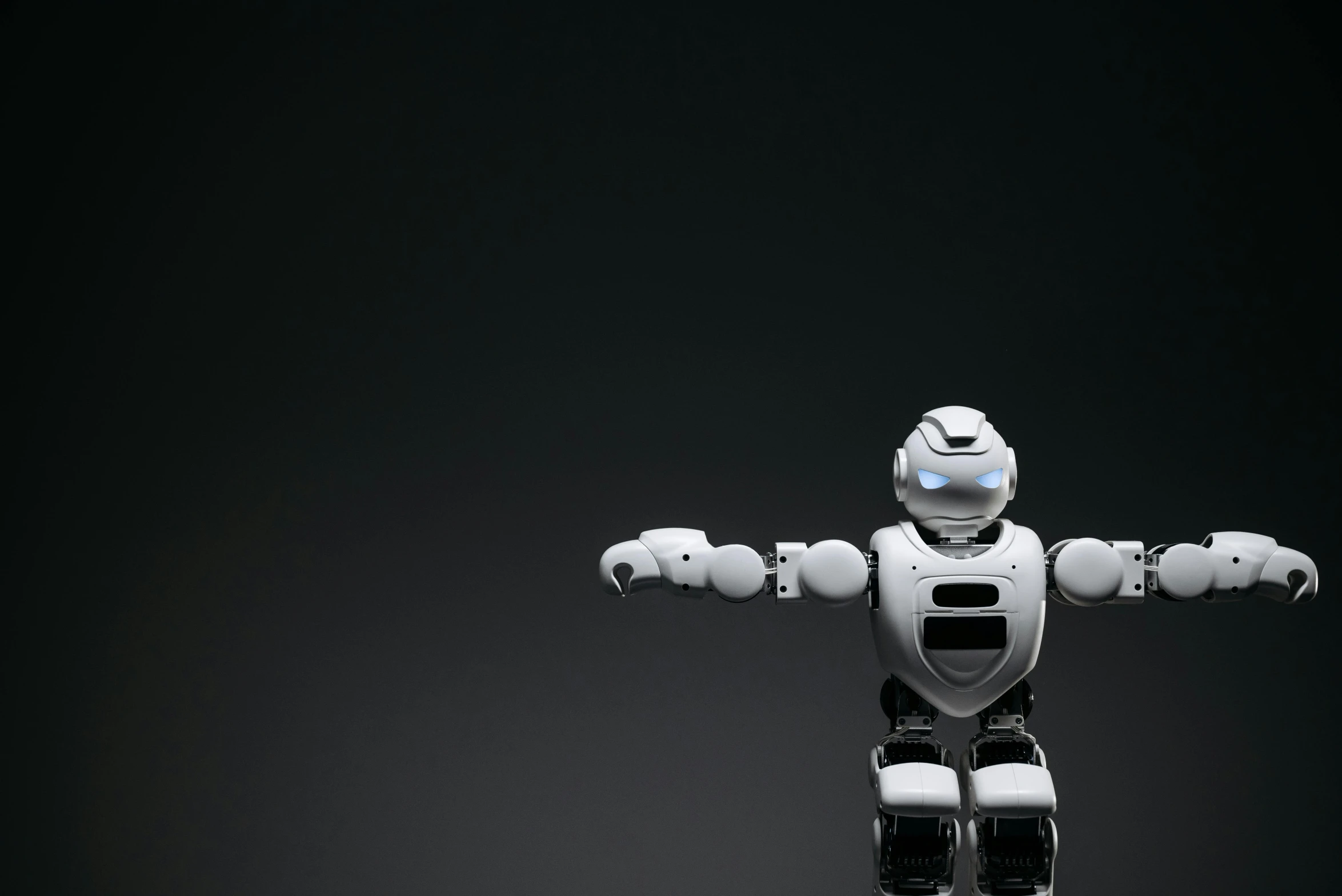 a white robot standing in front of a black background, by Adam Marczyński, shutterstock, fan favorite, on a gray background, waving, on grey background