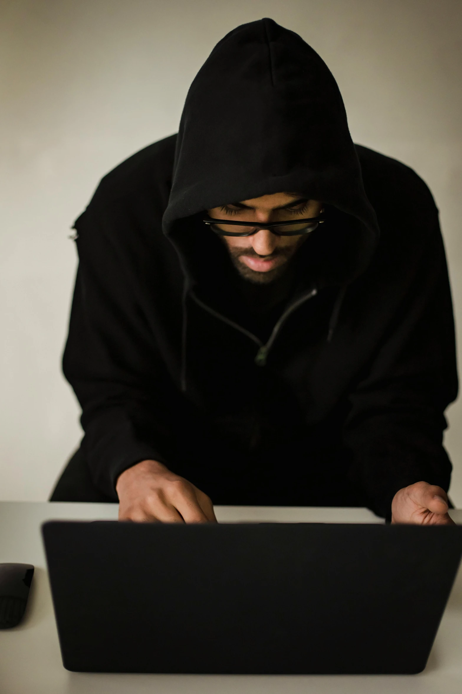 a man sitting in front of a laptop computer, pexels, computer art, black hood, brown, hashing, black