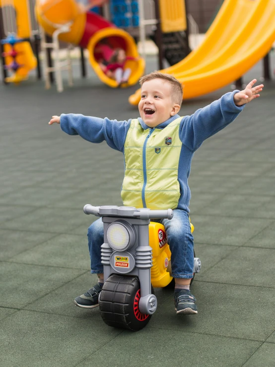 a young boy riding a toy motorcycle in a playground, a picture, by Alexander Fedosav, pexels contest winner, happening, triumphant pose, 15081959 21121991 01012000 4k, yellow, dasha taran