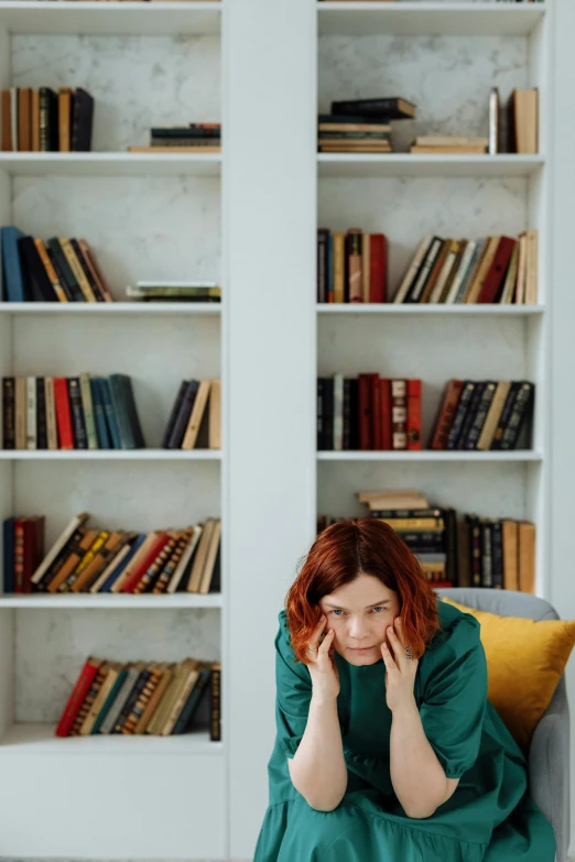 a woman sitting on a couch in front of a bookshelf, by Julia Pishtar, pexels contest winner, renaissance, sad christina hendricks, on a white table, books cave, 15081959 21121991 01012000 4k