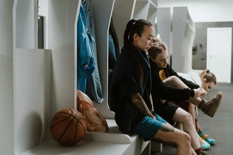 a group of people sitting next to each other in a room, basketball, lockers, bella poarch, profile image