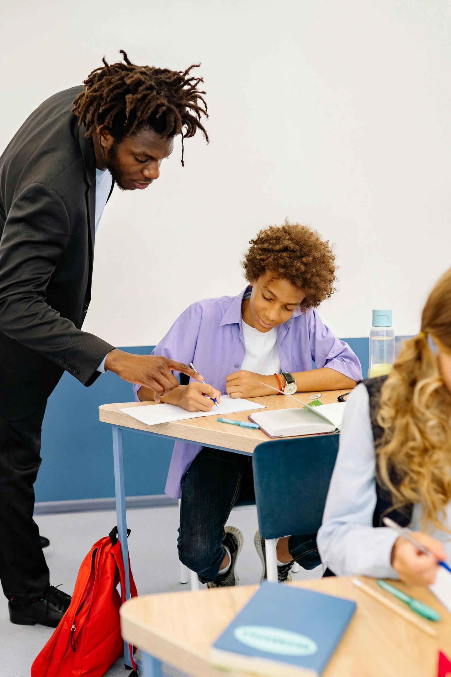 a group of children sitting at desks in a classroom, pexels contest winner, paris school, black man with afro hair, signing a bill, young thug, teacher