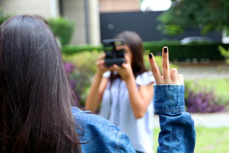 a woman taking a picture of another woman with a camera, pexels contest winner, realism, middle finger, ariana grande photography, hand photography, 15081959 21121991 01012000 4k