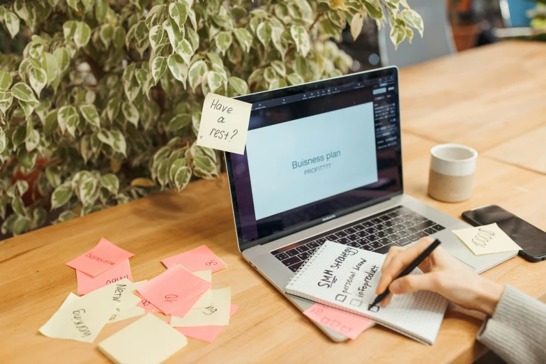 a laptop computer sitting on top of a wooden table, by Julia Pishtar, trending on unsplash, ink on post it note, 9 9 designs, with notes, épaule devant pose