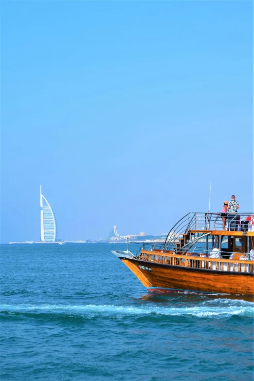 a boat in the middle of a large body of water, hurufiyya, gta : dubai, clear blue skies, busy crowds, old wooden ship