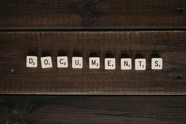 the word documents spelled in scrabbles on a wooden surface, by Joe Bowler, unsplash, graffiti, slide show, monument, old scientific documents, portrait image