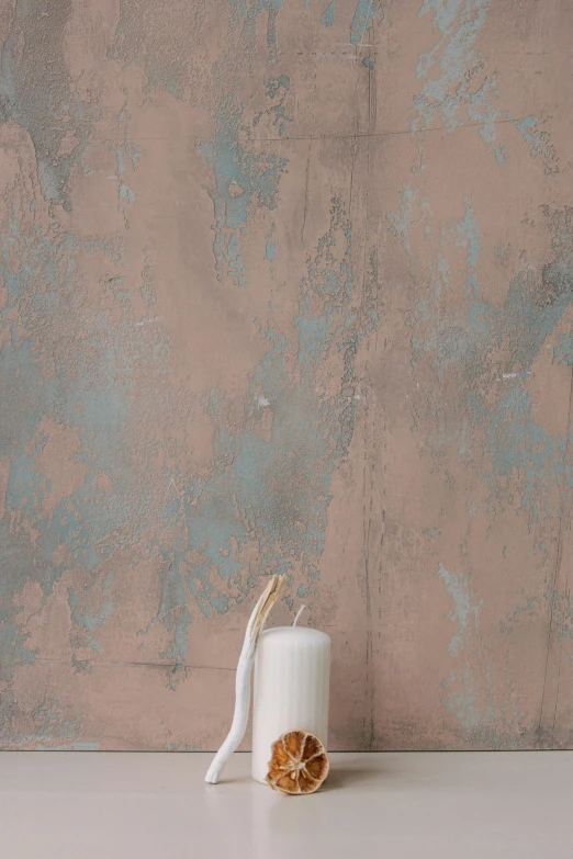 a candle sitting on top of a table next to a wall, inspired by Lucio Fontana, distressed paint, mauve and cyan, vertical wallpaper, muted brown