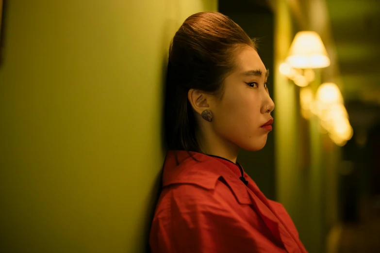 a woman leaning against a wall with her eyes closed, inspired by Wang Lü, trending on pexels, realism, dim red light, sangsoo jeong, moody : : wes anderson, portrait shot 8 k