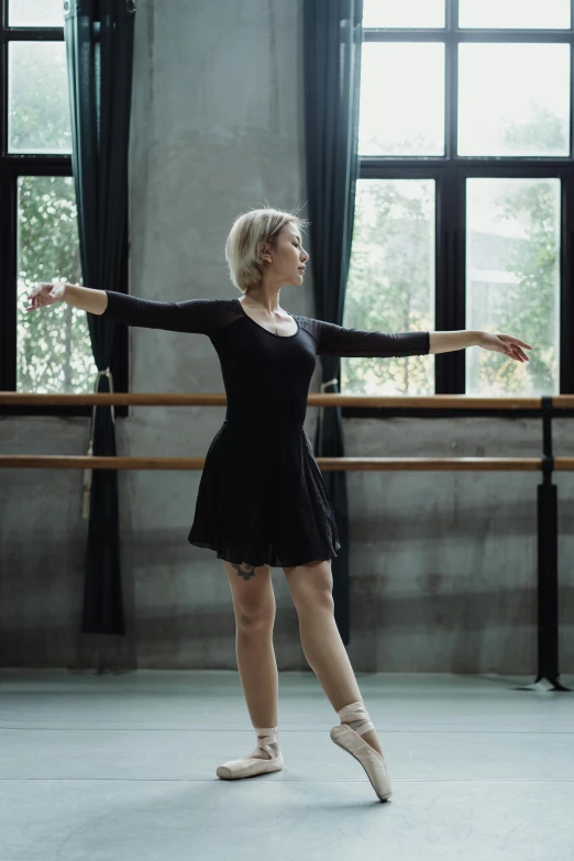 a woman in a black dress is practicing ballet, a portrait, trending on unsplash, anna nikonova aka newmilky, standing in class, full shot ( fs ), low quality photo